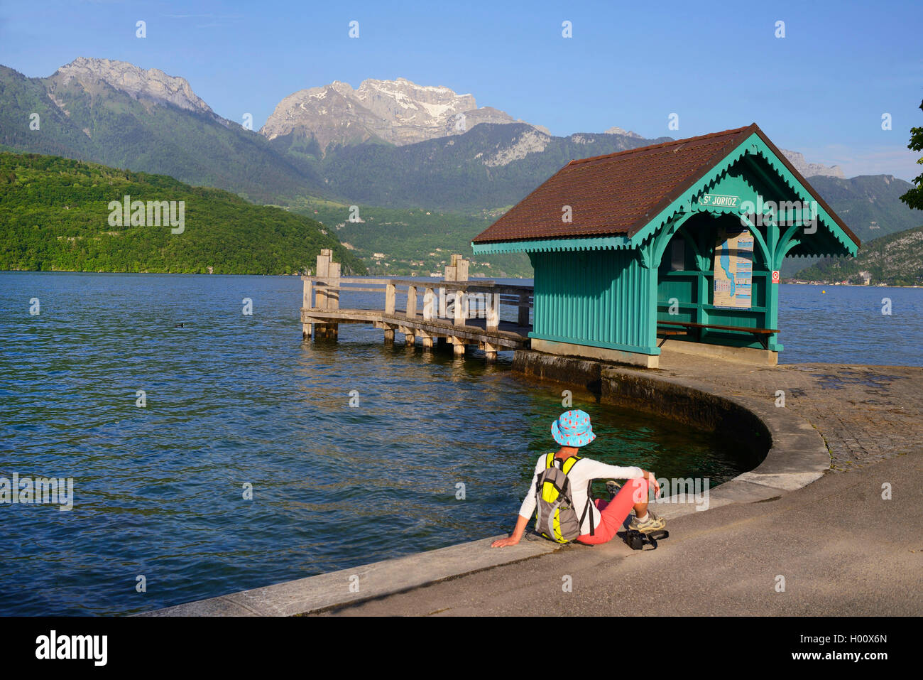 Mujer sentada en un embarcadero y cabaña de madera en el lago de Annecy, Francia, Haute-Savoie, Haute Savoie, Saint-Jorioz Foto de stock