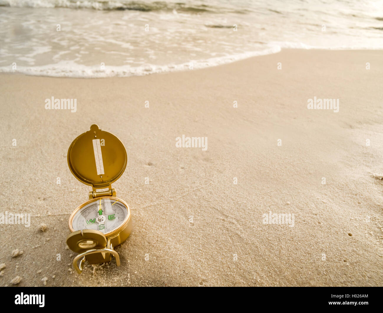 Brújula que indica la dirección de norte tumbado en la playa Foto de stock