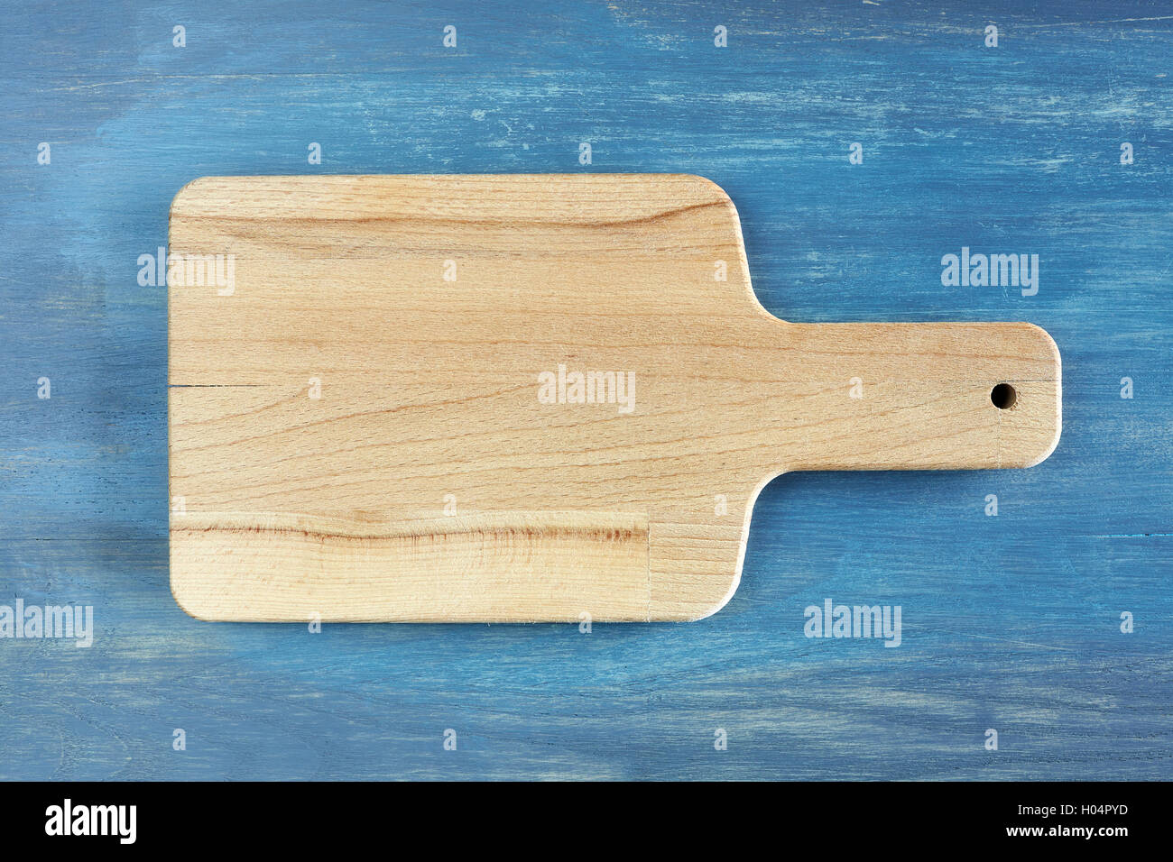 Tabla de cortar de madera vacías sobre la rústica mesa azul, fondo con espacio para texto, vista desde arriba. Foto de stock
