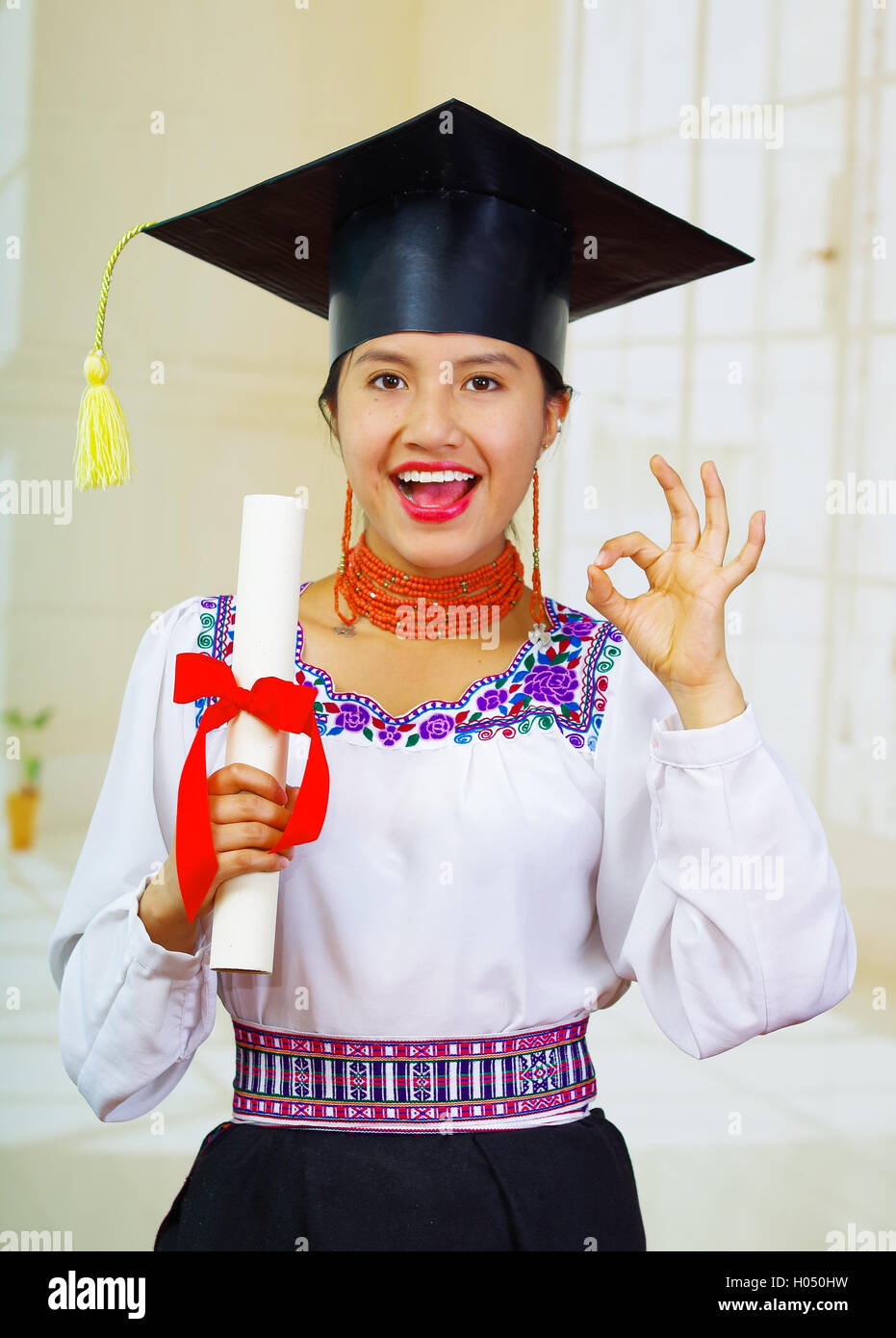 Joven estudiante vestido tradicional blusa y sombrero de graduación,  sosteniendo el diploma enrollado, sonriendo orgulloso de la cámara  Fotografía de stock - Alamy