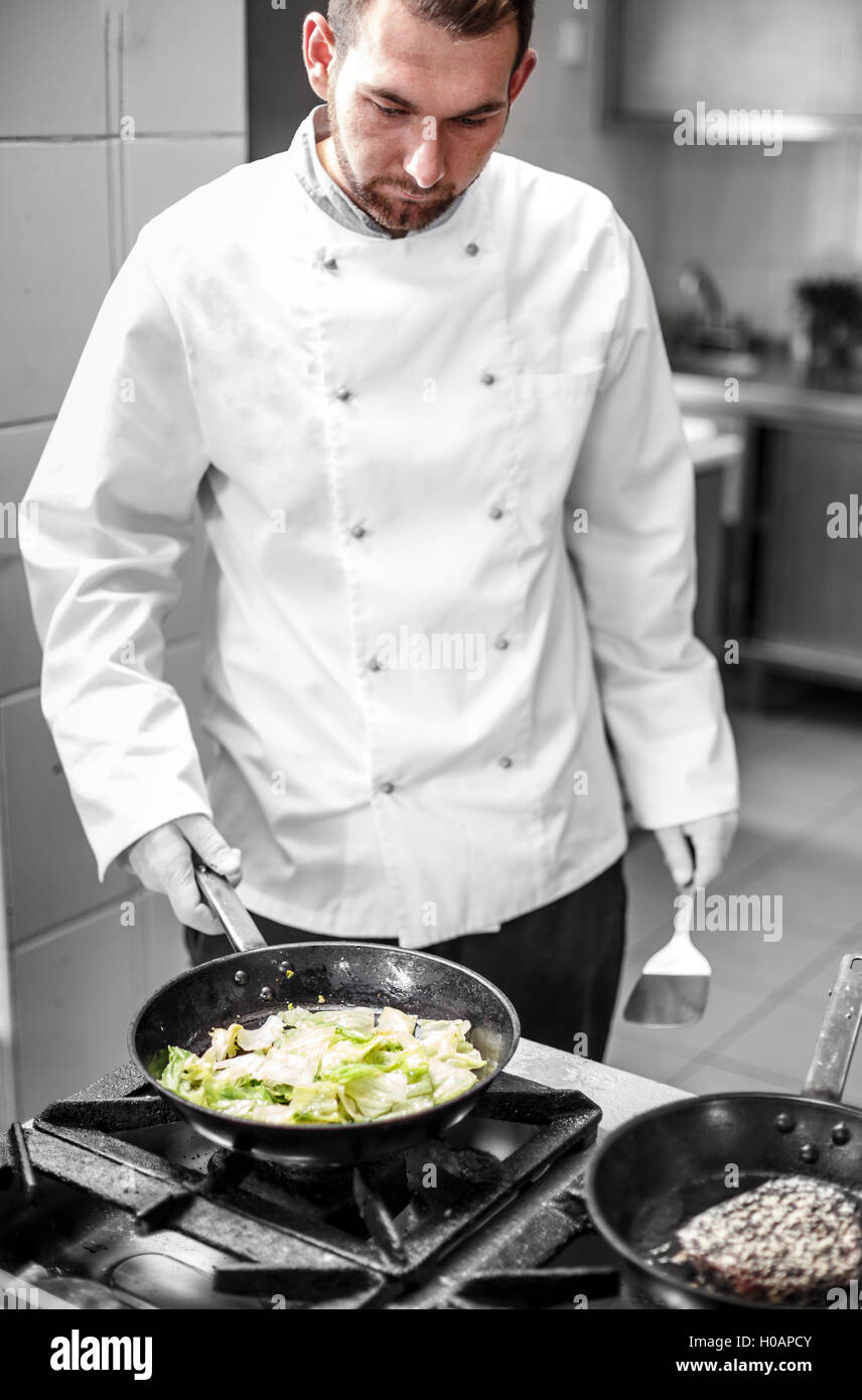 Chef de cocina de lechuga iceberg en pan, guarnición de filetes de atún rojo Foto de stock