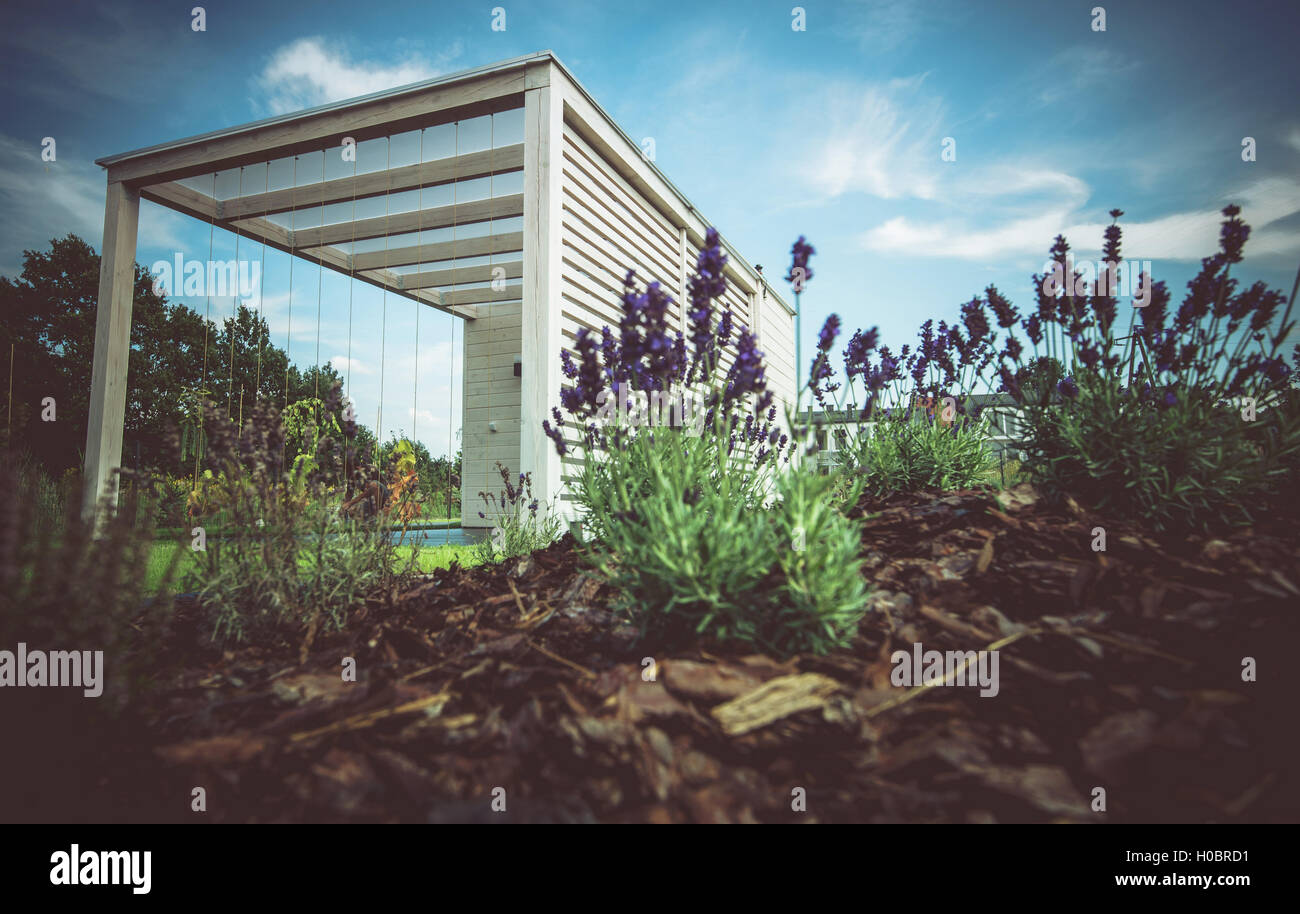 Gazebo blanco y moderno en el nuevo diseño del jardín. Mandril de