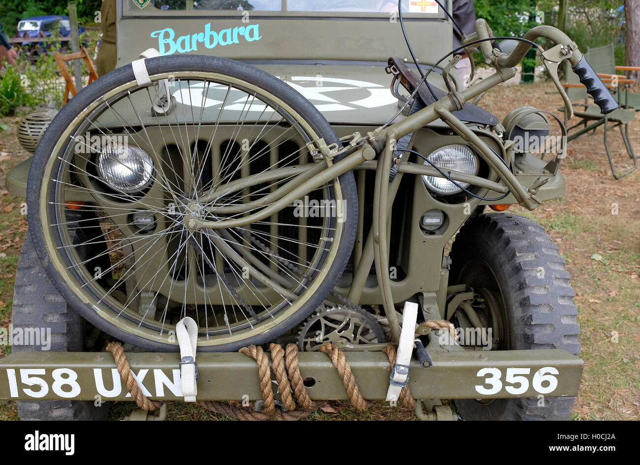Antigua bicicleta plegable en la parte delantera del jeep militar Foto de stock