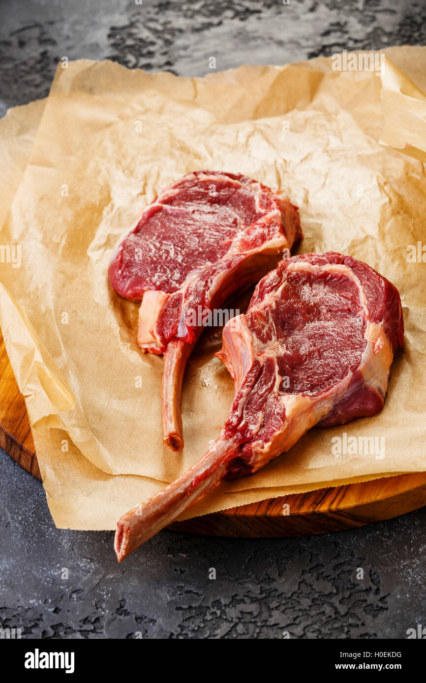 Carne fresca de ternera cruda Rib Steak en hueso sobre fondo oscuro Foto de stock