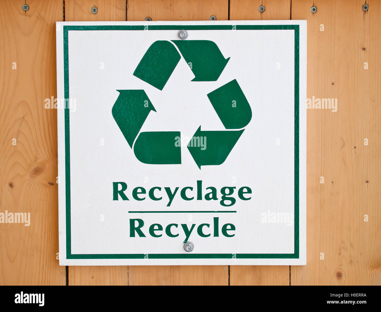 Reciclar plástico firmar sobre fondo de madera Foto de stock