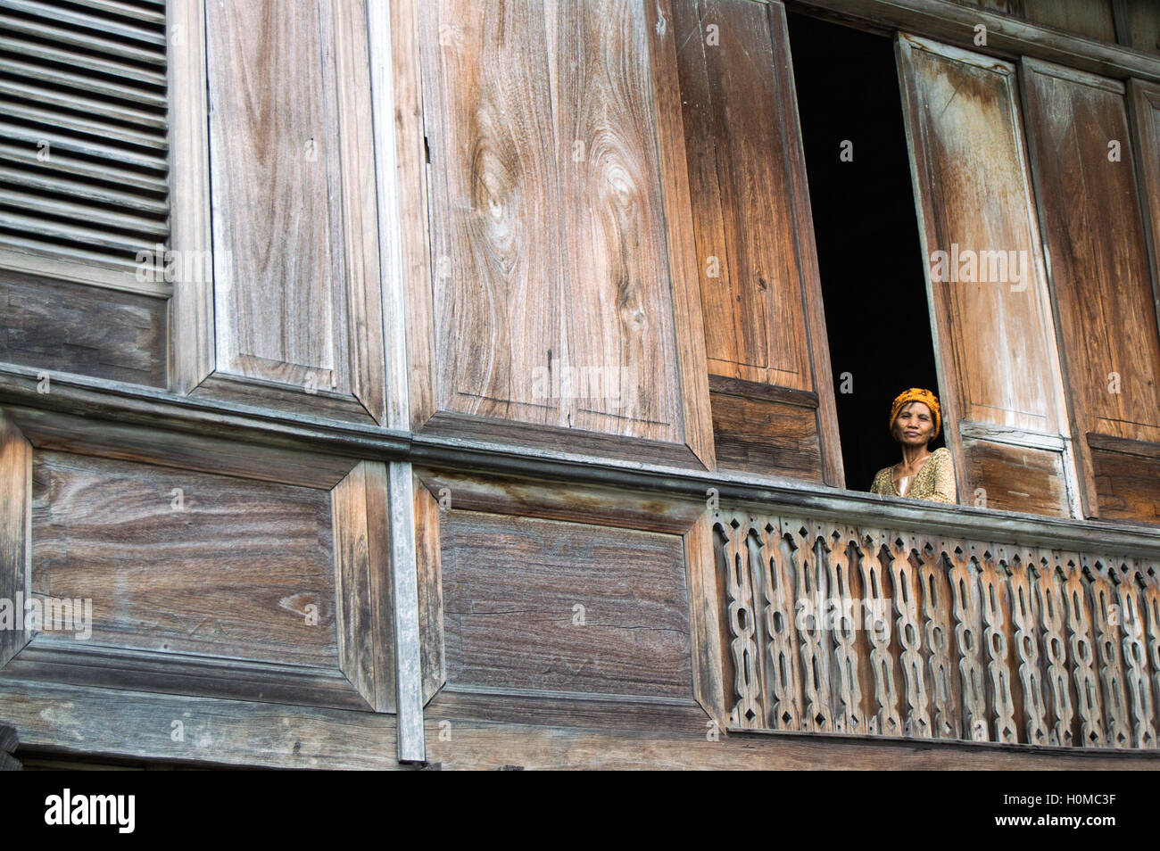 Mujer en la ventana de la mansión de madera vintage, Dumaguete, Negros Oriental, Filipinas Foto de stock