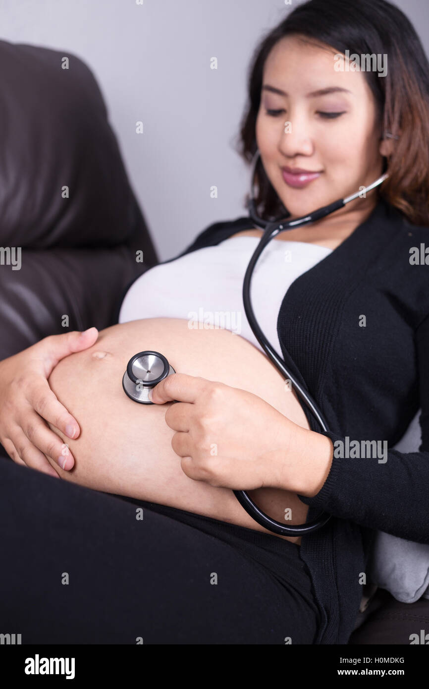Doctor Que Escucha El Latido Del Bebé En El Vientre De Una Mujer Embarazada  Fotos, retratos, imágenes y fotografía de archivo libres de derecho. Image  71712348