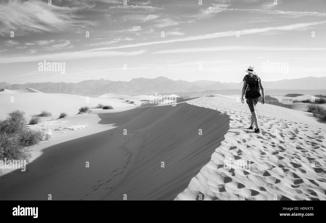 Joven excursiones turísticas en dunas de arena, dunas de arena plana, Mesquite, Faldas de Amargosa gama detrás, el Valle de la muerte Foto de stock