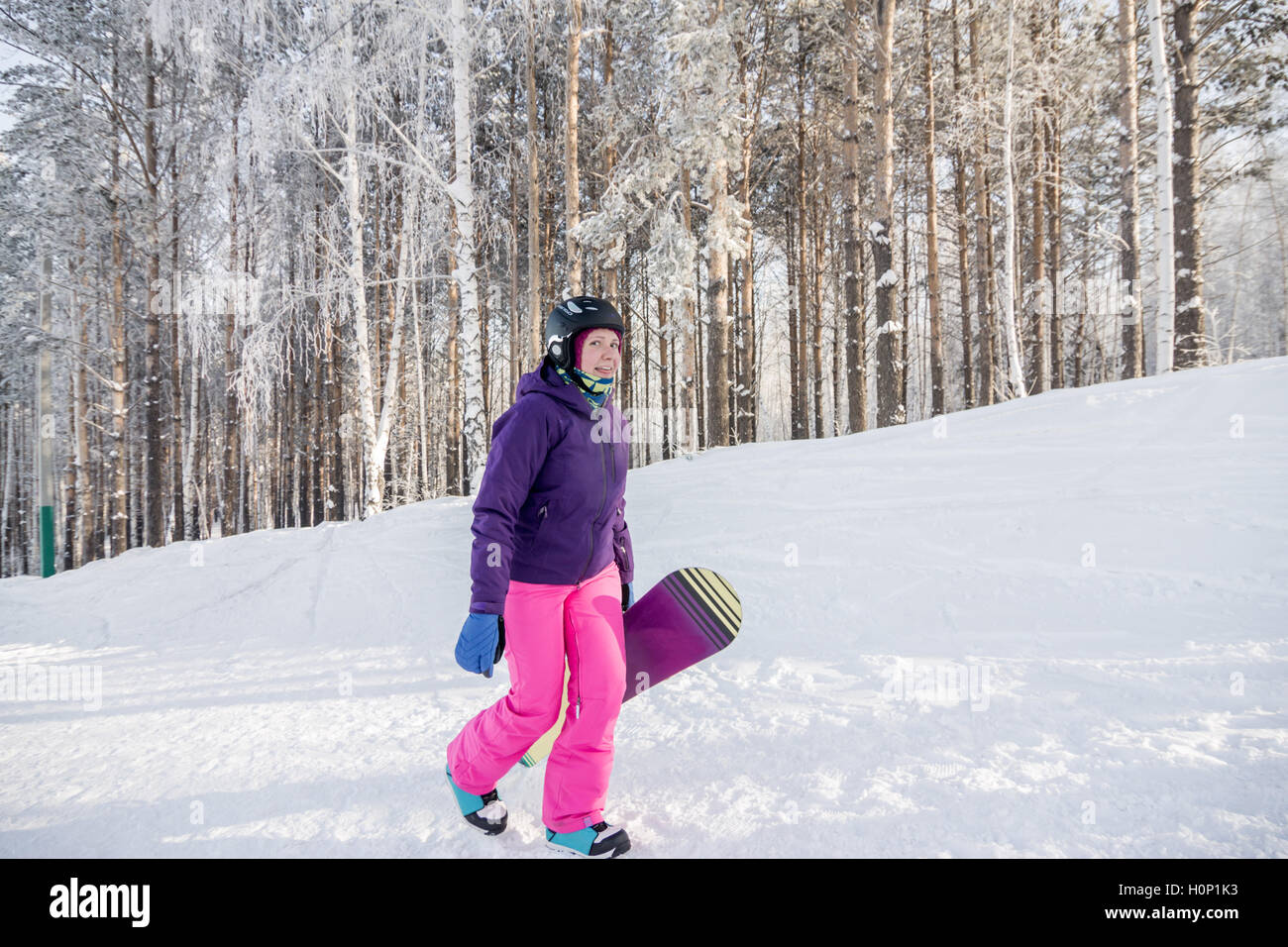Chica en violeta y rosa chaqueta con pantalón de snowboard en las manos de  la subida en invierno Fotografía de stock - Alamy
