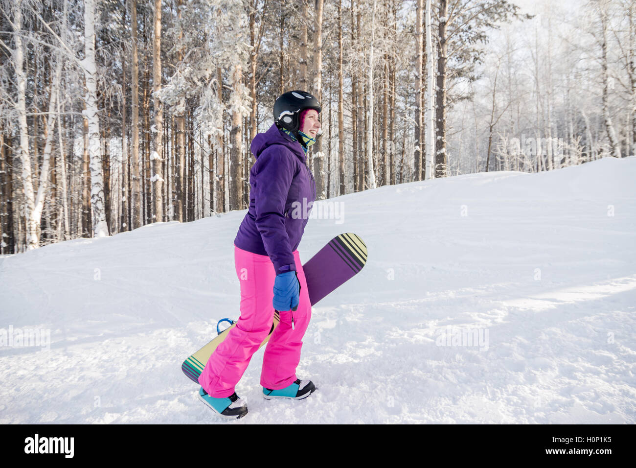 Chica en violeta y rosa chaqueta con pantalón de snowboard en las manos de  la subida en invierno Fotografía de stock - Alamy