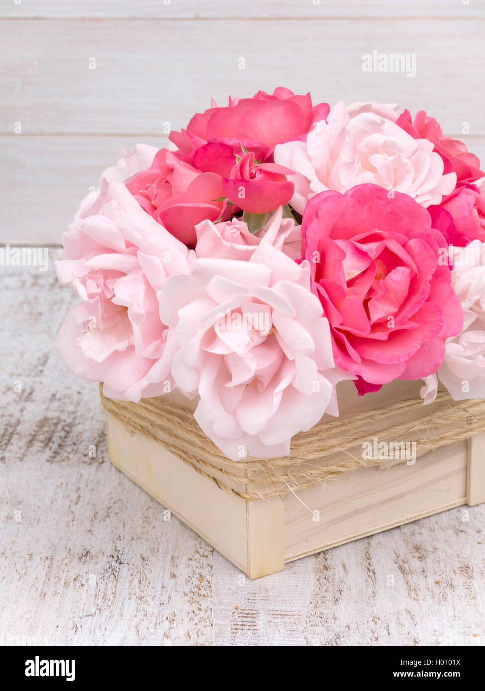 Rosa y Rosa Pálido ramo de rosas en la caja de madera atados con una cuerda de yute Foto de stock