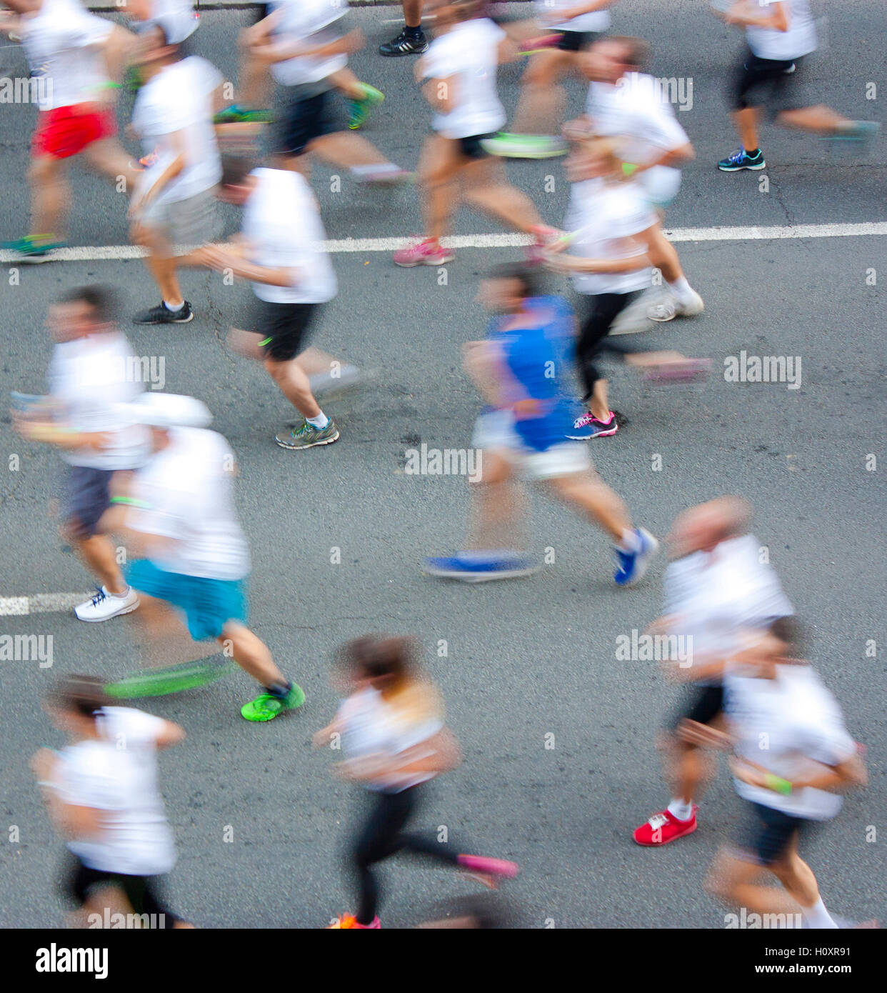 La gente ejecuta semi maratón en las calles de la ciudad en el desenfoque de movimiento atencionales Foto de stock