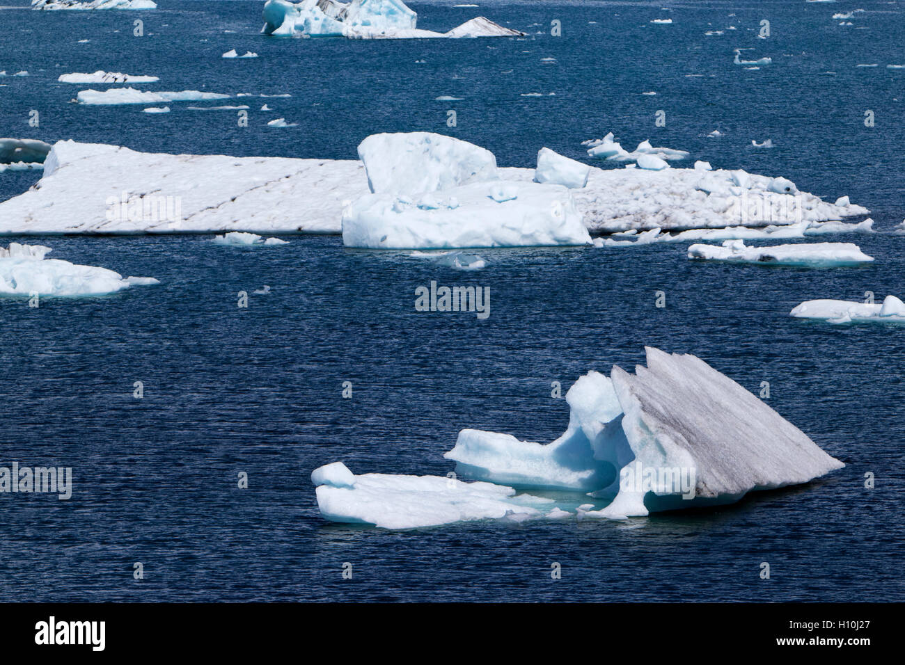 Laguna glaciar Jokulsarlon impregnados con ceniza icebergs sur de Islandia Foto de stock