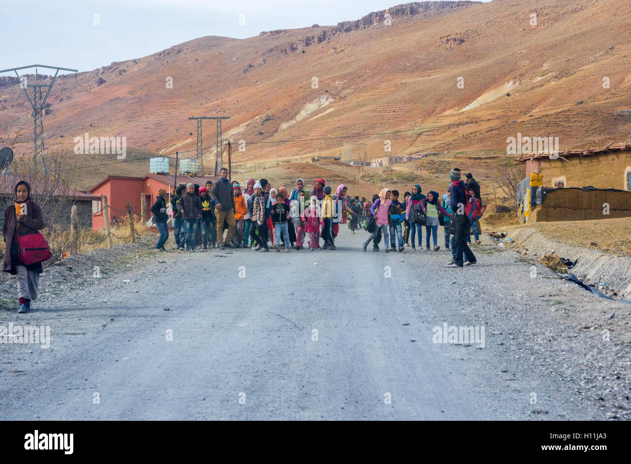 Un grupo de niños que regresan de la escuela en el medio de la carretera, en una aldea en las montañas del Atlas wysokiegu Foto de stock