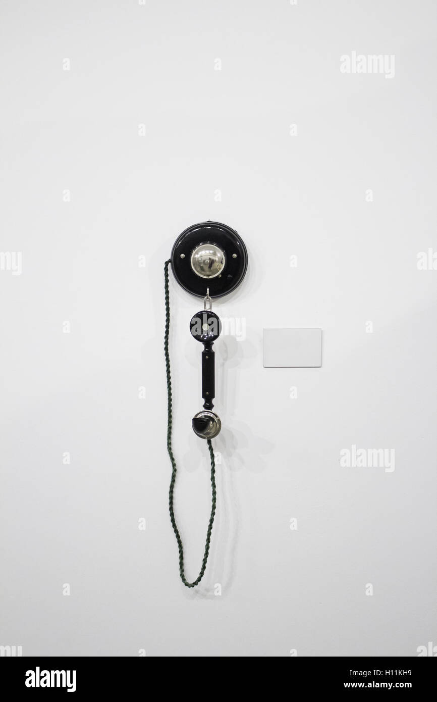 Teléfono colgado en la pared de plástico viejo, tecnología Foto de stock