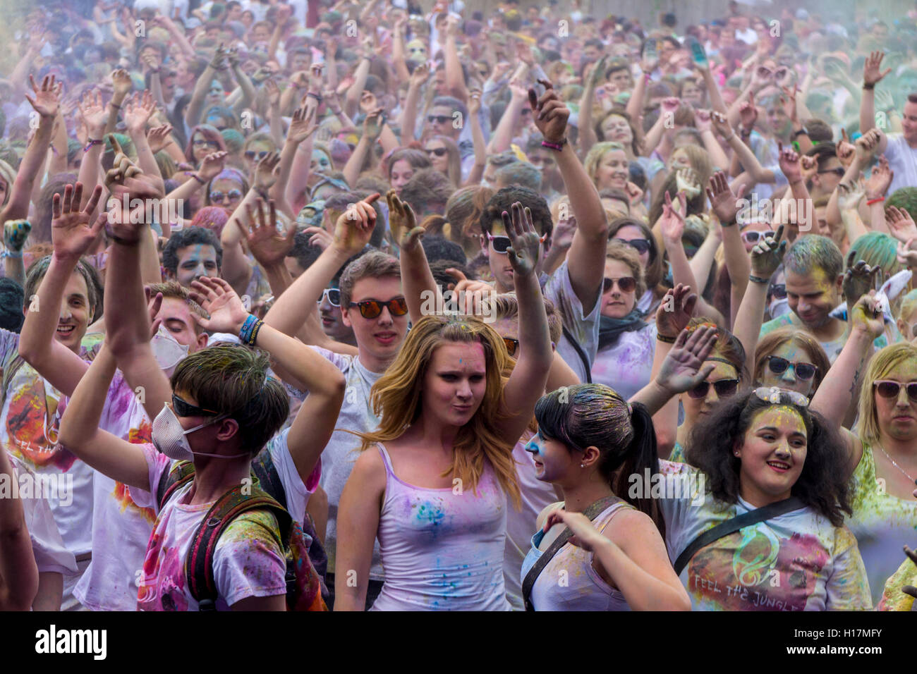 Miles de jóvenes mujeres y hombre están elevando sus brazos al colorido festival de Holi, Dresde, Sajonia, Alemania Foto de stock