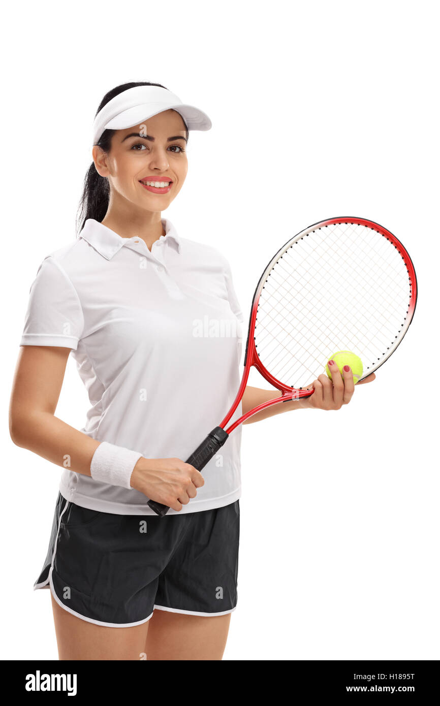 Jugador de tenis femenino posando con una pelota y una raqueta aislado sobre fondo blanco. Foto de stock