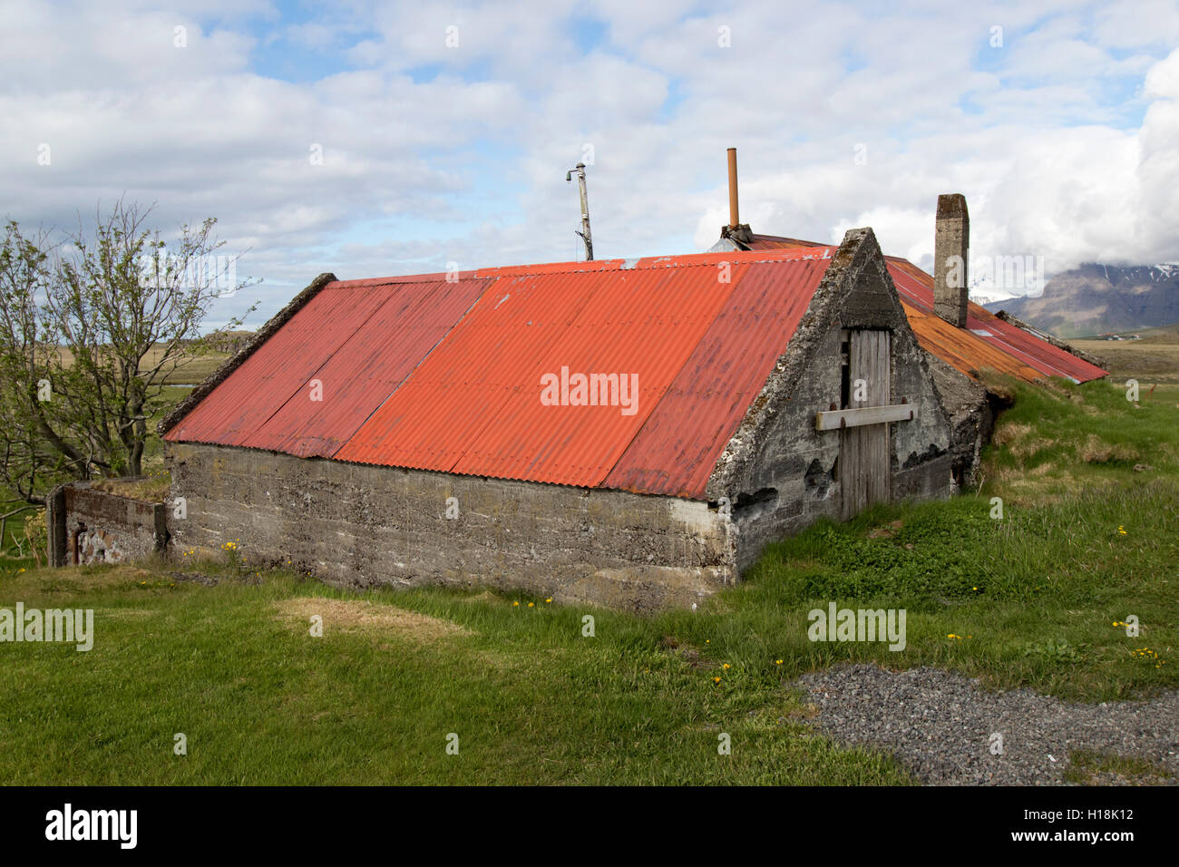 Parcialmente enterrada lata roja techada dependencias agrícolas en el sur de Islandia Foto de stock