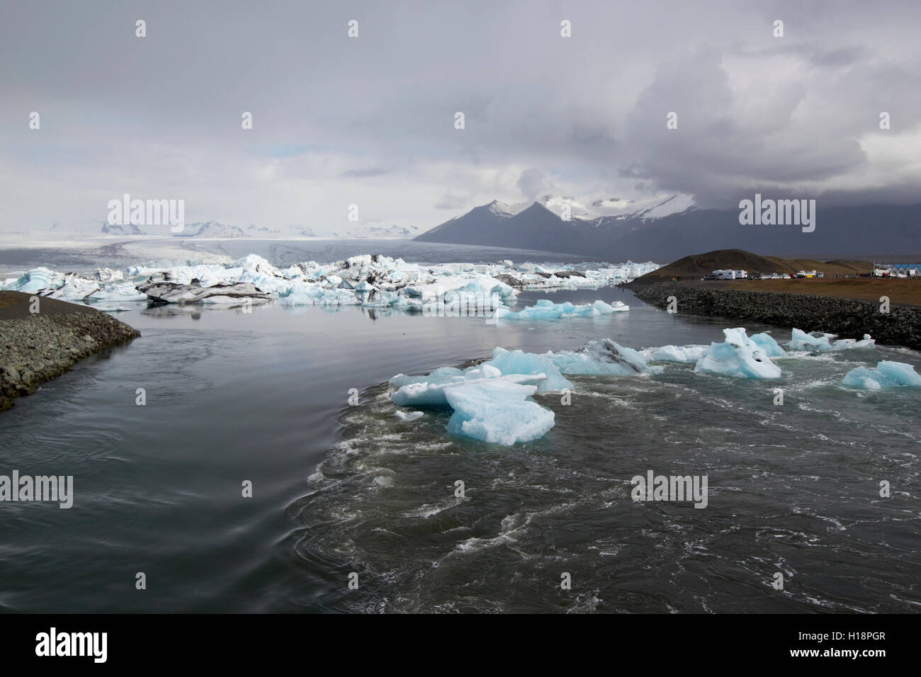 Los icebergs pasando por la ataguía en la Laguna glaciar Jokulsarlon Islandia Foto de stock