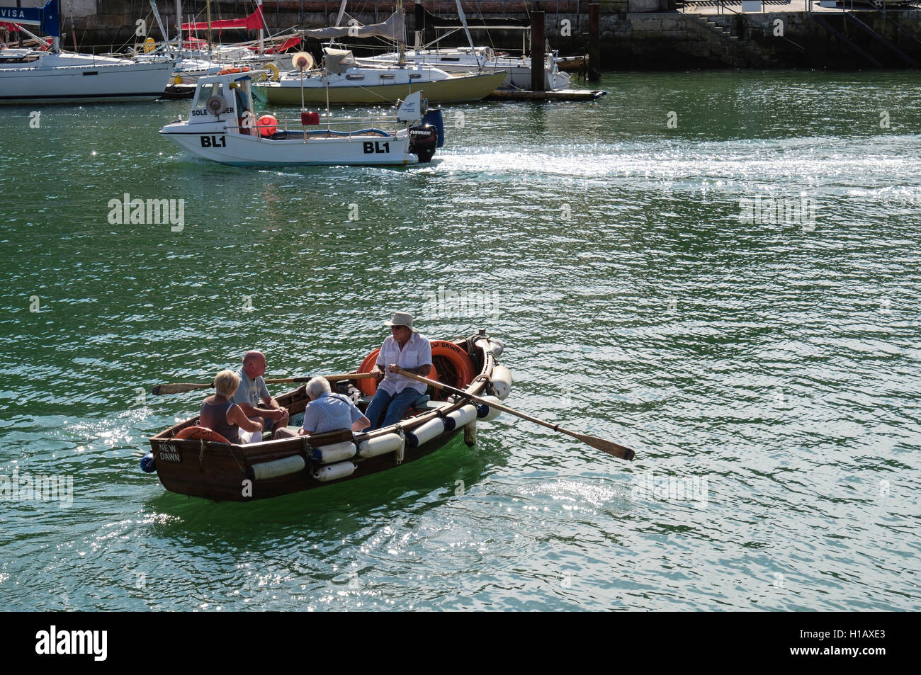 Barquero remo pequeño ferry de pasajeros en barco a través de la parte externa del puerto sobre el río Wey. Weymouth, Dorset, Inglaterra, Reino Unido, Gran Bretaña Foto de stock