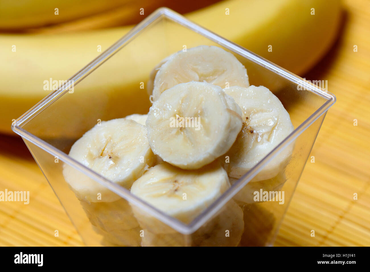 Rodajas de plátano y banano en tazón Foto de stock