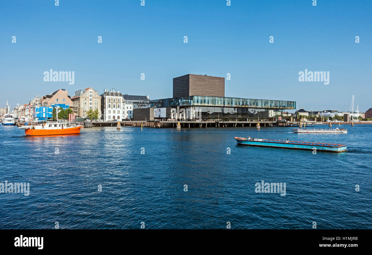 Skuespilhuset (Royal Danish Playhouse) por el puerto de Copenhague Dinamarca como visto desde la orilla del mar con barcos de canal Foto de stock