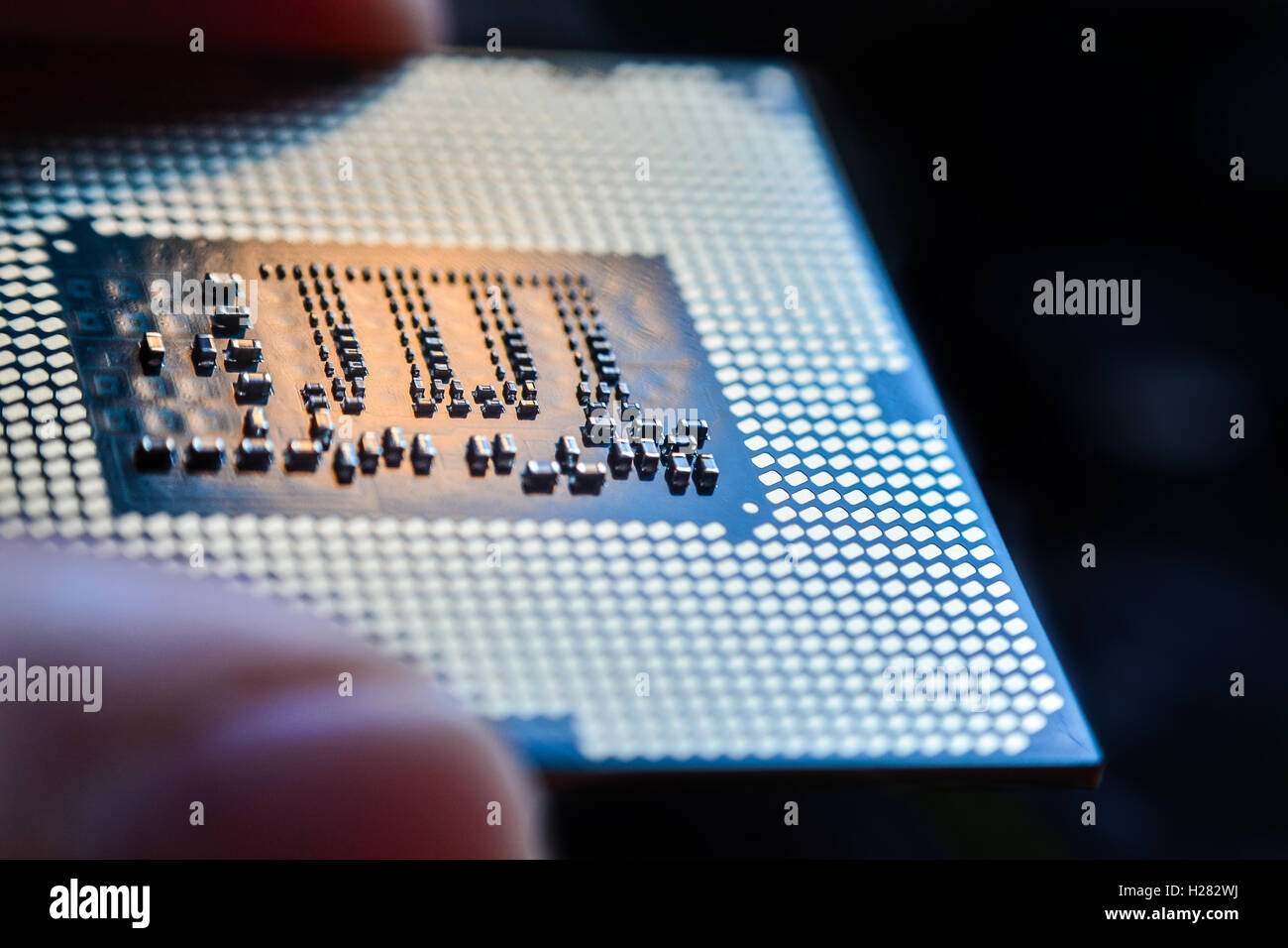 Equipo micro chip de procesador de la CPU entre los dedos cerrar Foto de stock