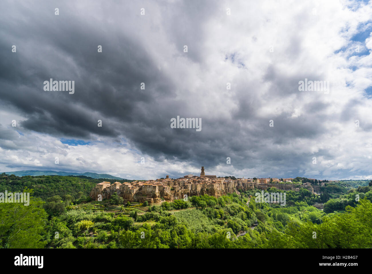 La ciudad sobre la colina y cielo nublado, Pitigliano, Toscana, Italia Foto de stock