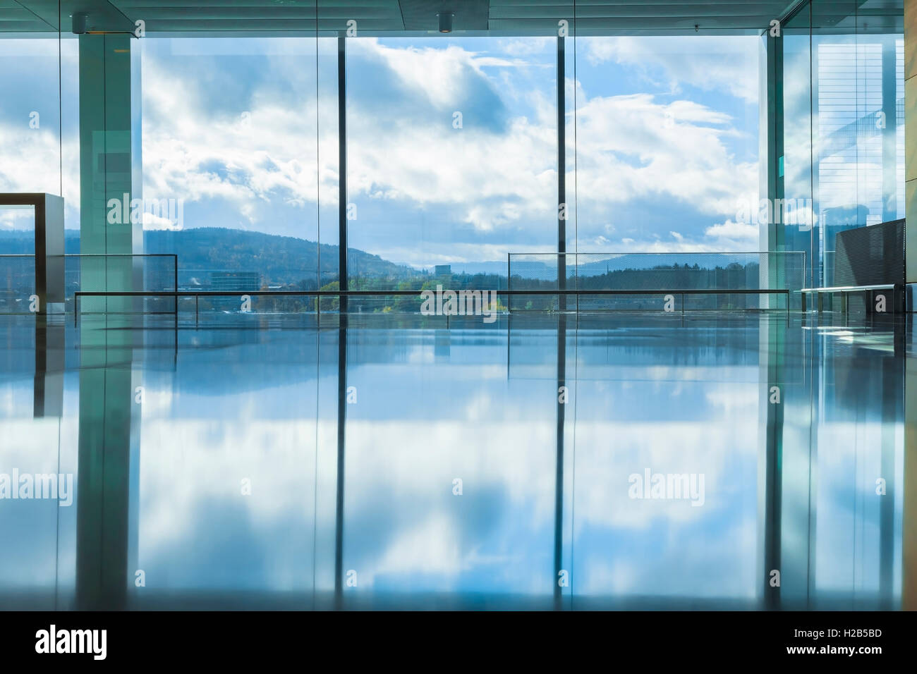 Vaciar el interior de un edificio moderno con un reflejo de cielo azul Foto de stock