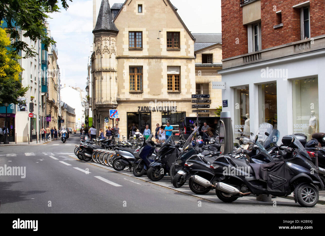 Vista de motocicletas estacionado en una de las calles en el barrio de Le Marais. Tiendas de moda y arquitectura de estilo tradicional francés Foto de stock