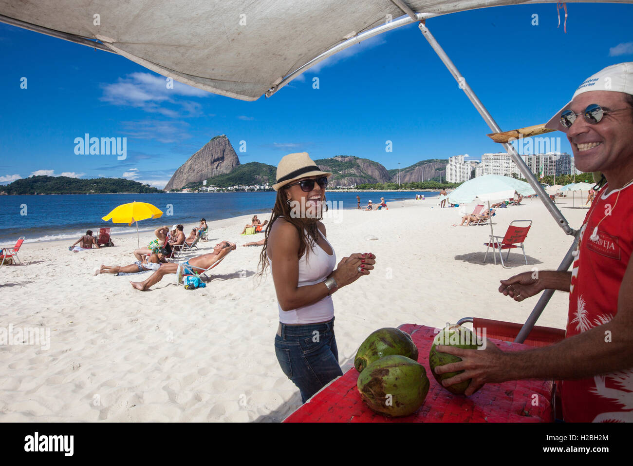 Bonita morena mujer brasileña bebe agua de coco en la playa de Flamengo,  Sugarloaf mountain en el fondo, Río de Janeiro, Brasil Fotografía de stock  - Alamy