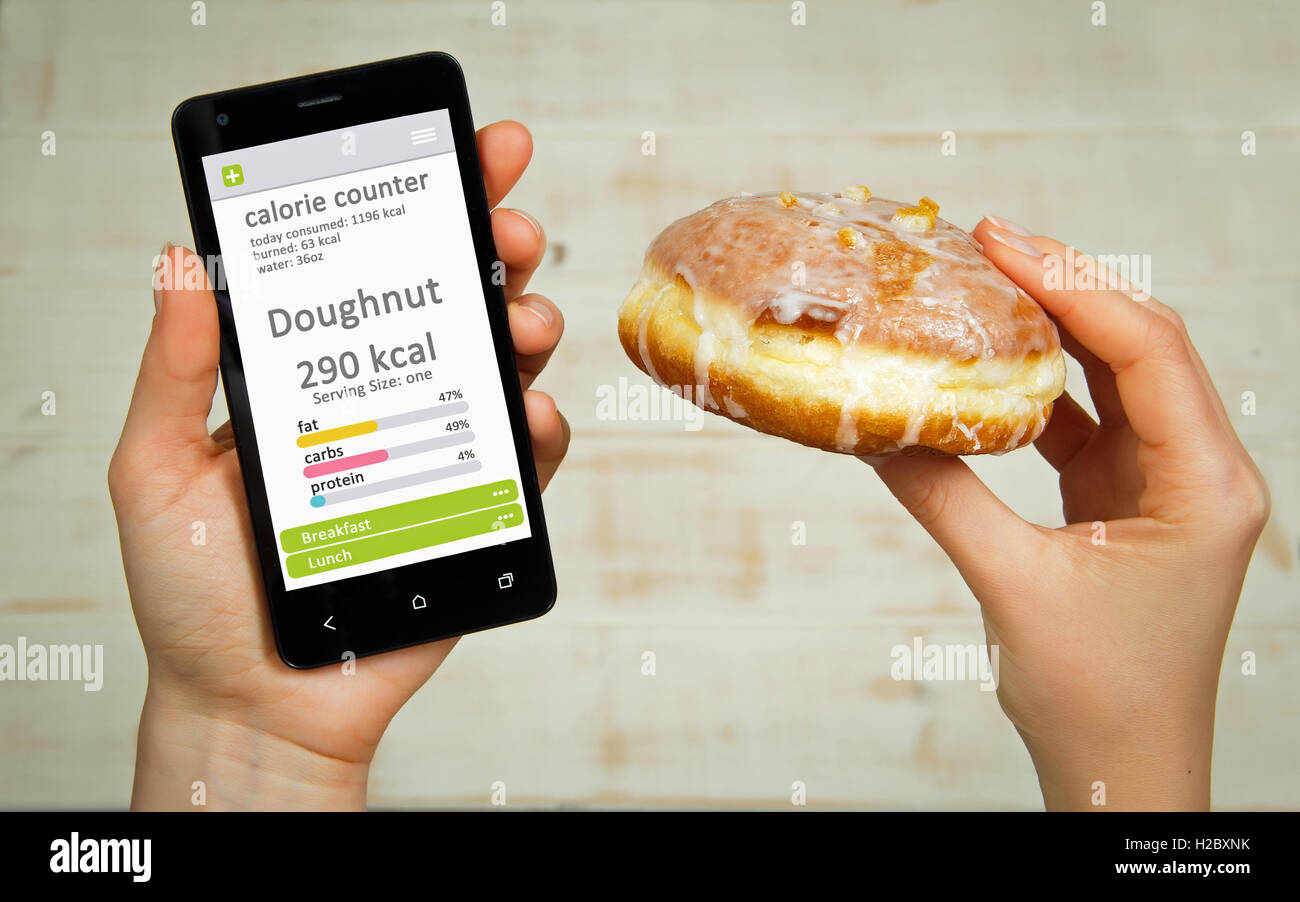 Contador de calorías concepto - joven sosteniendo el teléfono móvil con el contador de calorías de app en la pantalla. Foto de stock