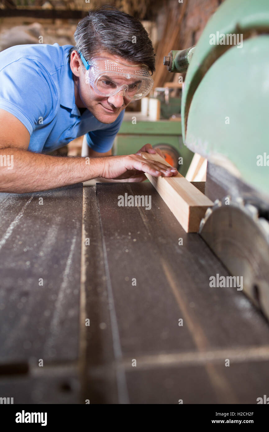 Carpenter cortando madera en Sierra circular Foto de stock