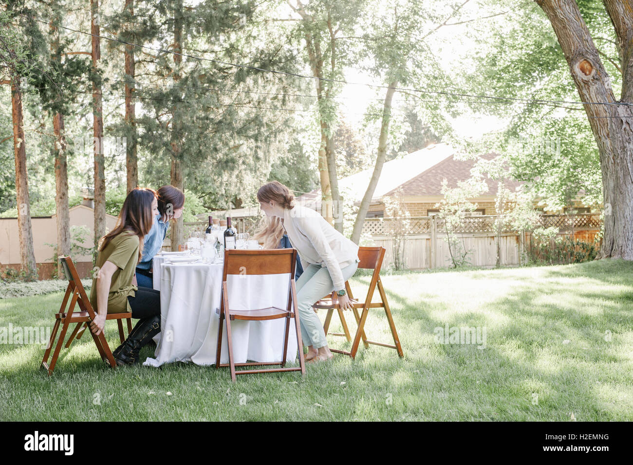 Grupo de mujeres sentadas alrededor de una mesa en un jardín. Foto de stock