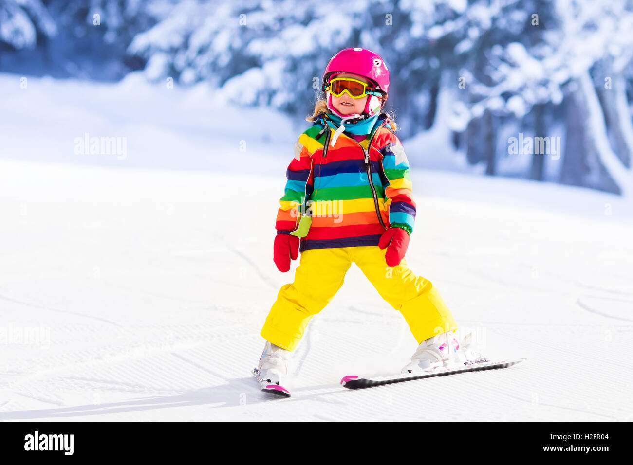 Niño esquiar en las montañas. Active toddler niño con casco de seguridad,  gafas y polacos. Carrera de esquí para niños pequeños Fotografía de stock -  Alamy