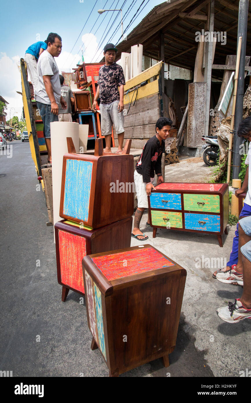 Indonesia, Bali, Mas, hombres cargando camión con reproducción recién hechas, shabby chic muebles pintados Foto de stock