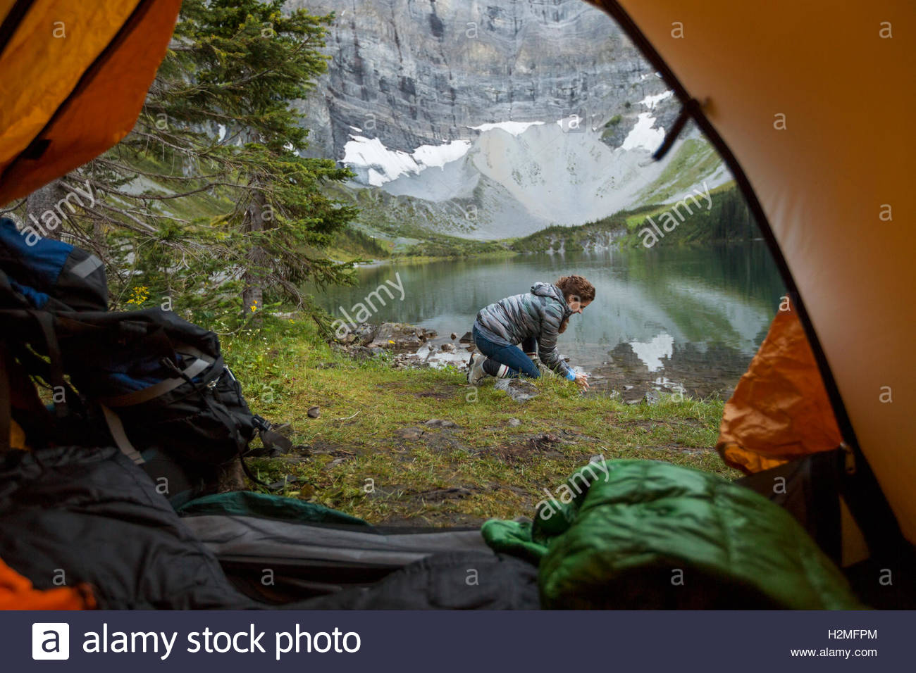 Mujer en lago remoto fuera de camping carpa Foto de stock