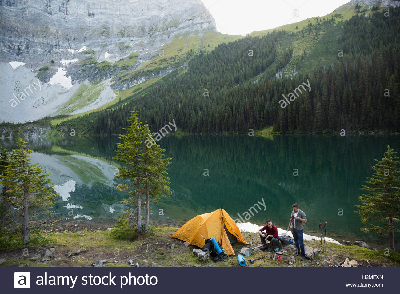 Amigos varones camping camping lago de montaña remotos Foto de stock