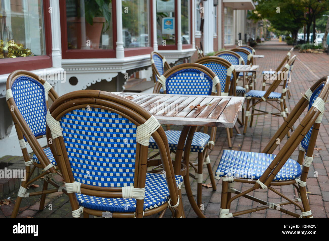 Un café en la acera desierta en Chestertown Maryland tejida con sillas azules. Foto de stock