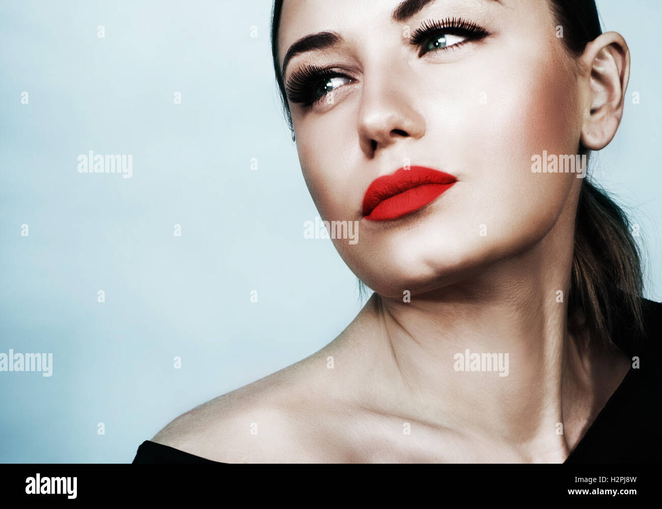 Closeup retrato de una bella mujer sobre fondo azul, modelo atractivo sexy con labios rojos y la noche perfecta maquillaje Foto de stock