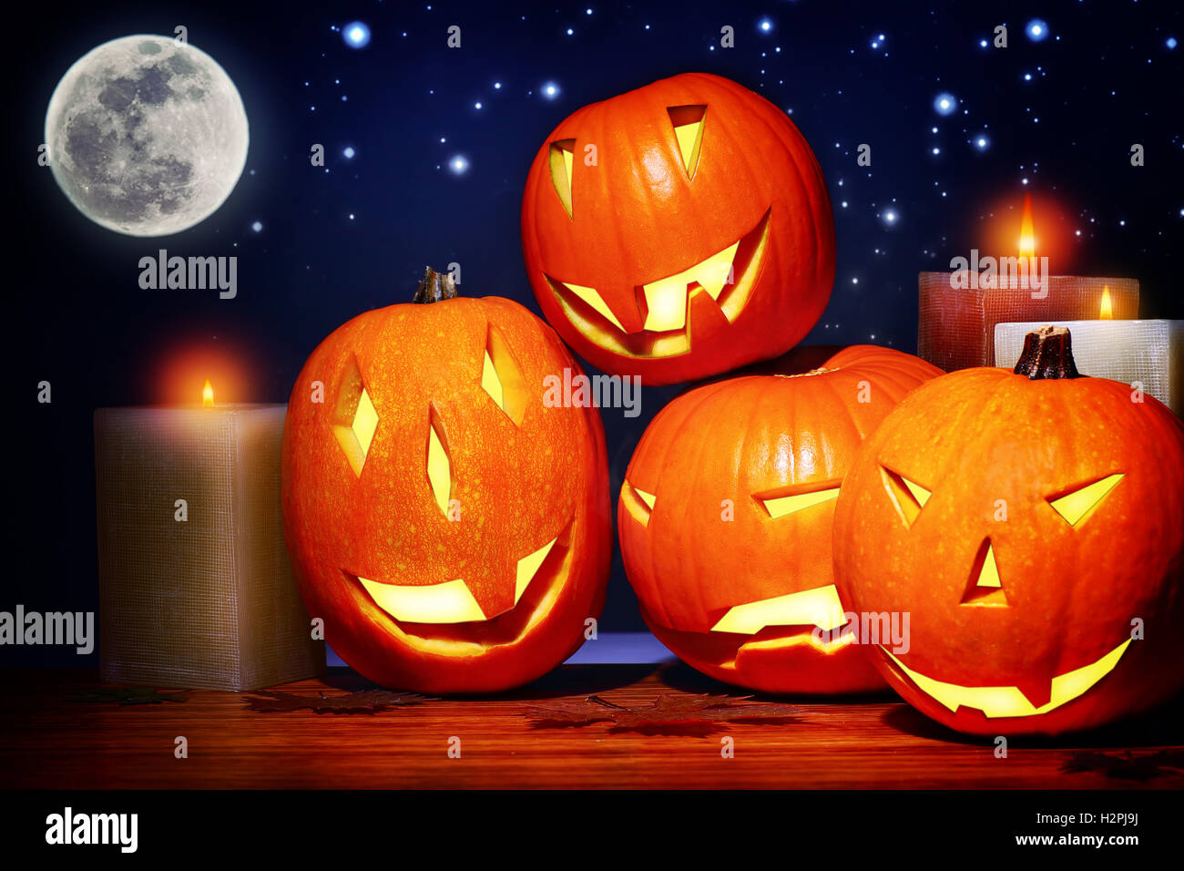 Fiesta de Halloween decoración festiva, terrorífico bodegón sobre fondo de cielo estrellado, calabazas talladas caras como jack-o-lantern Foto de stock