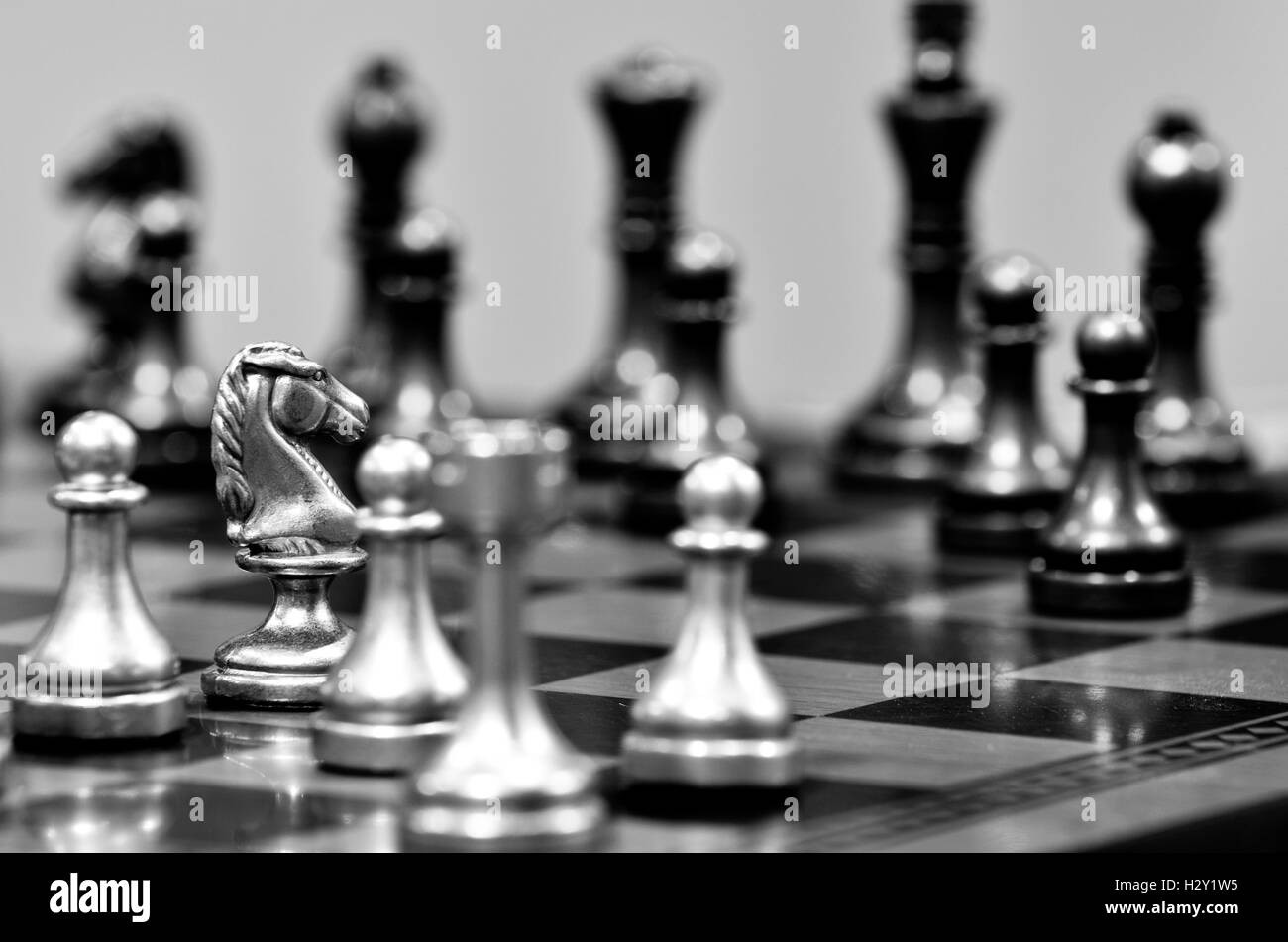 Tablero de ajedrez con white knight frente opositor en el partido Foto de stock