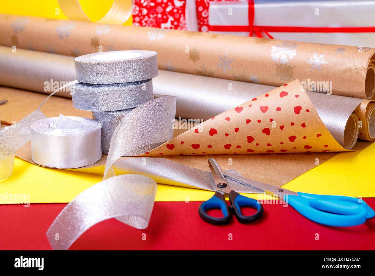 Envoltura de regalos, cajas, papel, cinta y tijeras sobre fondo de color.  Los accesorios y los materiales para envolver regalos. Cerca Fotografía de  stock - Alamy