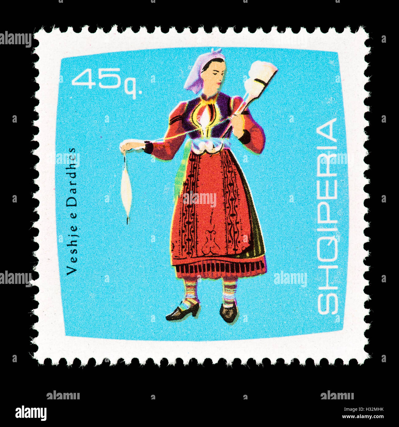 Sello de Albania representando una mujer spinner, Dardhes, en locales de ropa. Foto de stock