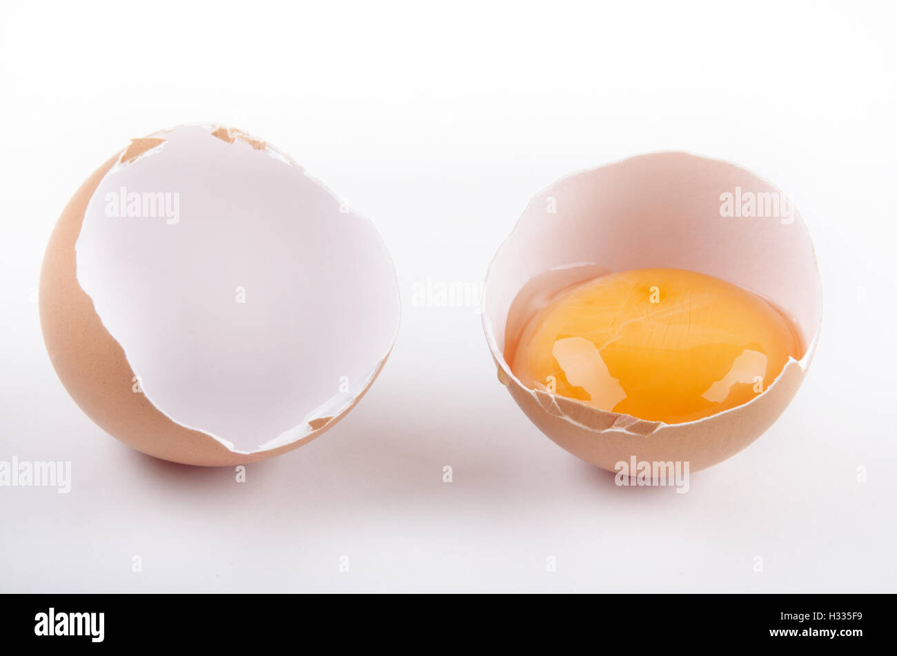 Cascarón vacío agrietado y yema de huevo Fotografía de stock - Alamy