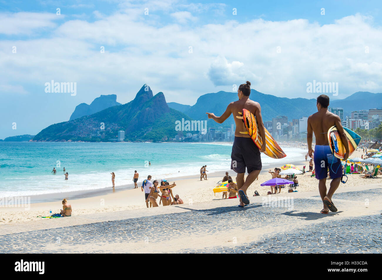 RIO DE JANEIRO - Abril 3, 2016: el joven surfista brasileño carioca caminar con tablas de surf de Arpoador, el popular surf point. Foto de stock