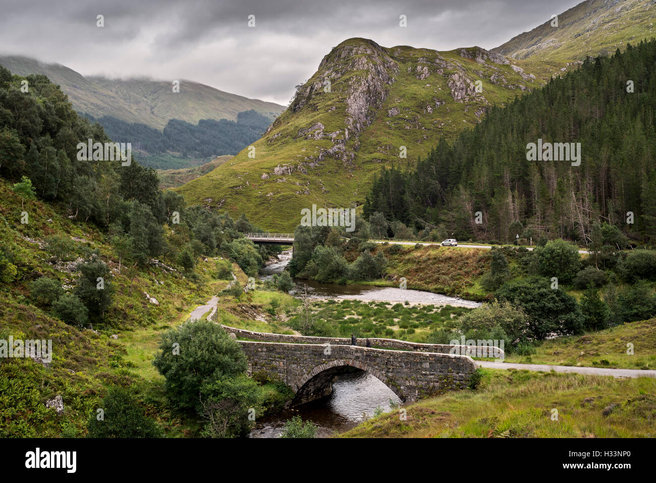 Los restos del antiguo camino militar y el puente sobre el río Shiel en Glen Shiel, Kintail, Scottish Highlands, Scotland, Reino Unido Foto de stock