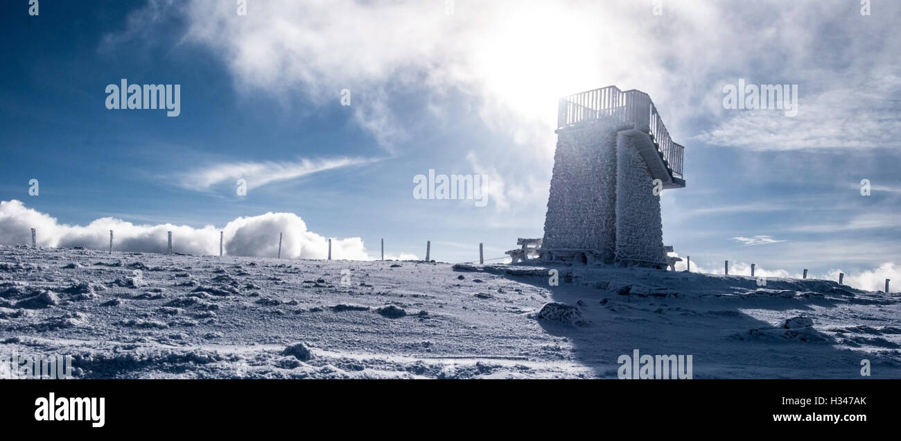 Colina pretualpe con hielo cubierto de grava y punto de observación el cielo azul con nubes en invierno fischbacher alpen en Estiria Foto de stock