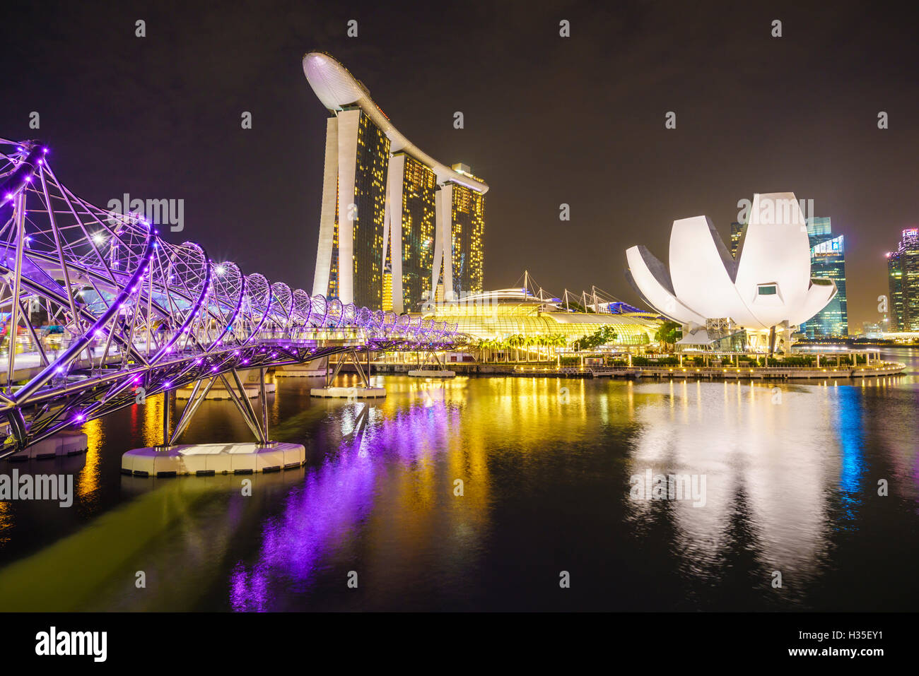 Helix Bridge, Marina Bay Sands y museo ArtScience iluminados durante la noche, Marina Bay, Singapur Foto de stock