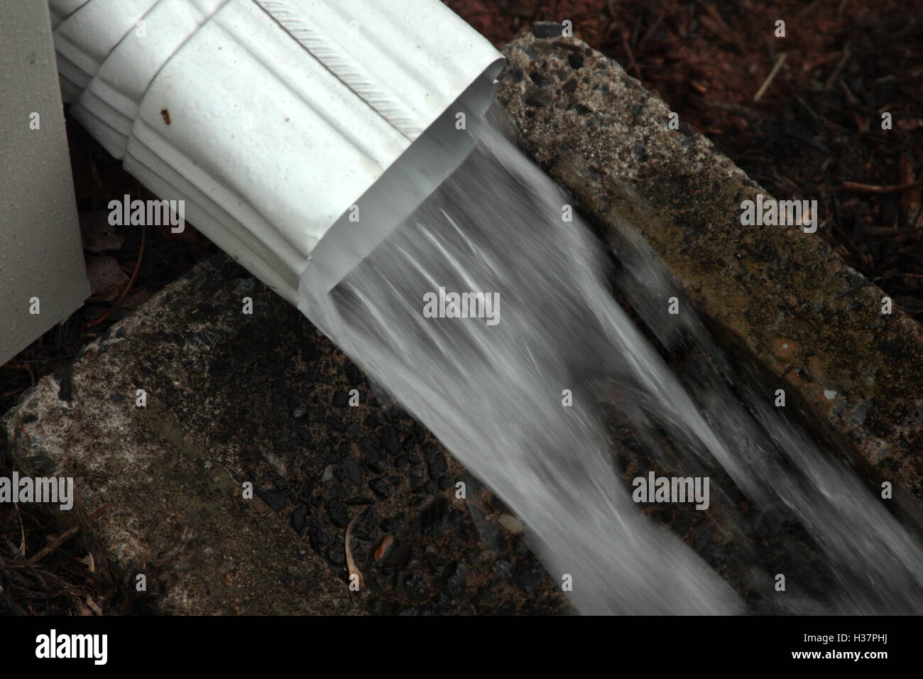 El agua de lluvia que fluye desde el tubo de bajante Foto de stock